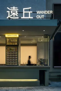 A modern retail storefront with minimalist design, featuring concrete and glass materials.