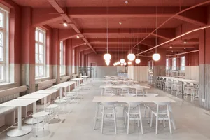 Large, spacious cafeteria with modern, light-colored furniture seating.