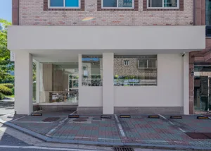 A modern coffee shop exterior with glass and concrete materials.