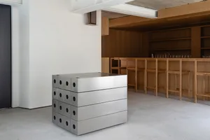 A modern metal counter bar with a minimalist design, featuring industrial-style metal boxes arranged in a cube-like structure
