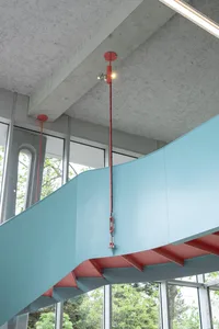 Modern, sleek staircase with red accents and a steel rail.