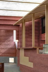 A modern restaurant bar with concrete and wooden surfaces, featuring a counter and minimalist design.