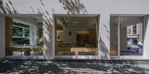 A modern restaurant interior with glass walls and white walls