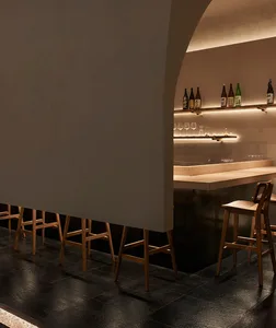 Industrial-style bar interior featuring wooden stools and leather seating.