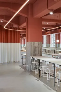 Industrial-style cafe interior with concrete ceiling, white curtains, and white stools