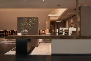 A modern restaurant interior with a wooden counter and seating area.