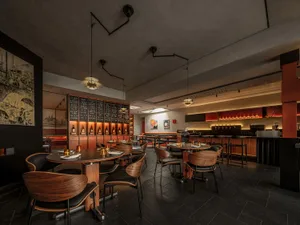 Modern restaurant interior featuring wood, leather, metal, and glass materials.