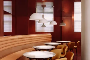 A modern restaurant interior with marble tables and a leather seating area.