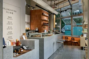 Contemporary cafe bar featuring a granite and concrete countertop and a teak wood backdrop.