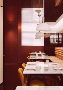 Modern restaurant interior with marble tables and leather chairs.
