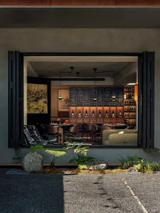 Modern restaurant bar with wooden furniture and concrete walls, featured in a Brewbar & Kitchen setting.