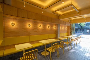 Modern restaurant interior with yellow walls and furniture