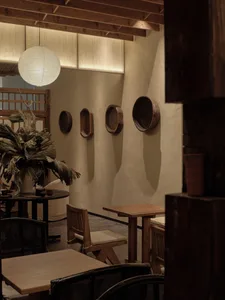 A wooden restaurant interior featuring tables, chairs, and decorative elements.