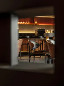 Interior view of a restaurant with a modern industrial design featuring wood and leather elements