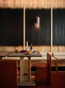 A modern restaurant interior with a wooden table and chairs, featuring a sleek design and minimalist aesthetics.