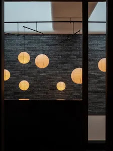 Paper lanterns hanging from a brick wall