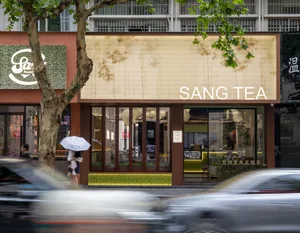 帶有玻璃面板的零售店面，門口有「SANG TEA」招牌。