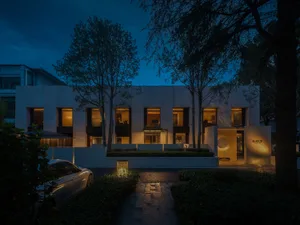A modern building with a minimalist design featuring large windows and a clean, white exterior.