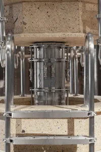 An industrial machine with metallic components and a concrete base.