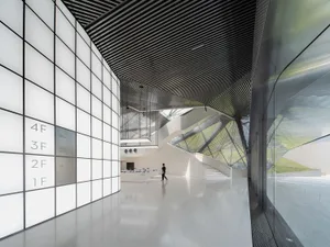 A modern interior space featuring concrete and glass elements.