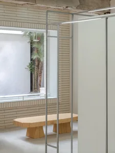A modern interior with concrete walls, lighting fixtures, and a wooden table.