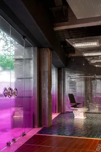 Modern public toilet with glass walls and concrete flooring