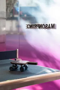 A table tennis paddle attached to a skateboard, suggesting a playful fusion of table tennis and skateboarding