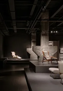 Industrial-style interior featuring a concrete pillar and wooden furniture, showcasing contemporary design elements.