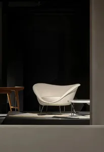 Modern minimalist lounge featuring a plush, fabric-covered chaise with a sleek, ergonomic design.
