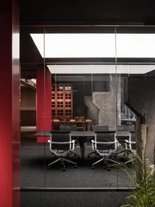 Modern office interior with industrial design featuring concrete walls and minimalist furniture.
