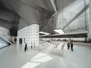 A spacious, white-tiled office with glass walls and metal accents