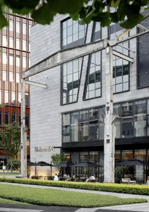 Modern restaurant exterior with concrete facade and large glass windows.