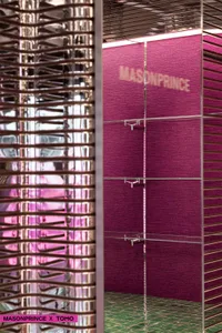 A modern retail storefront featuring metallic facades, textured fabric panels, and glass elements.