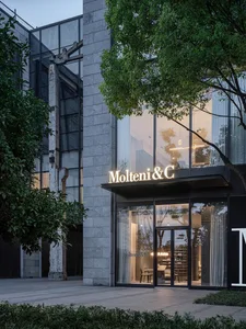 Modern storefront featuring glass, concrete, and lighting elements.