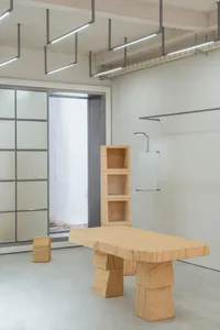 A modern stone furniture set featuring a table, a bookshelf, and a bench.