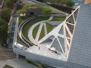 A modern architectural design featuring glass, concrete, and metal materials.
