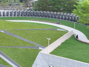 A public park area featuring green roofs with grass and concrete walkways and seating.