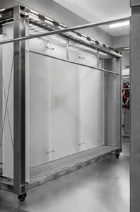 A modern industrial clothing rack with a steel frame and metal shelves.