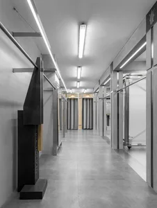 A minimalist corridor with metal railings and gray walls.