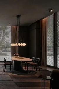 Modern dining room featuring a marble table, black chairs, and a hanging chandelier.