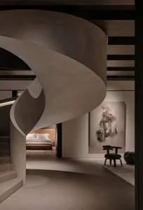 Modern minimalist residential interior with concrete staircase and artwork.