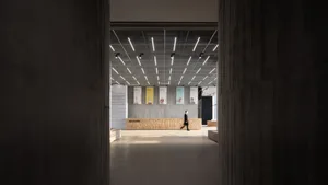 A modern industrial-style lobby with concrete walls and floors, featuring a minimalist design and contemporary lighting fixtu