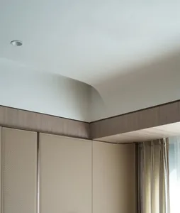 Modern minimalist bedroom with textured beige wall paneling and curtain.
