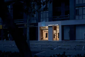 A modern minimalist retail storefront with white tiles and black glass windows.