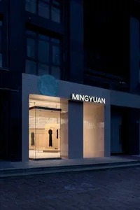 Modern retail storefront with large windows displaying minimalist clothing.