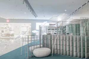 A minimalist retail shop featuring large, white, glass walls, and a floor-to-ceiling display area.