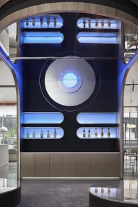A modern bar display with blue lighting featuring various bottles.