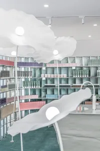 A modern retail space featuring minimalist white interior design with sculptural white flowers.