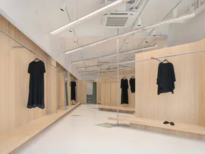 Modern interior design featuring clothing hangers, with wooden walls and minimalist aesthetic.