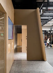 Industrial-style office space with a doorway, brownboard, and a mix of materials like wood, glass, and concrete.
